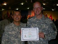 Army Sgt. Andreas Buttner, right, displays his certificate of citizenship as he stands next to his escort, Army Chief Warrant Officer 3 Allan Mace, at Kandahar Airfield, Afghanistan, Jan. 29, 2011. U.S. Army photo  